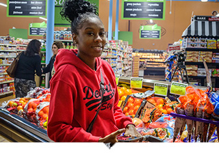 Woman shopping for produce at Imperial Fresh Market grocery store in Detroit